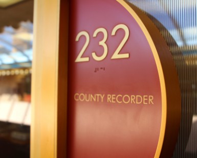 A closeup view of the sign outside the door of Suite 232 that says County Recorder