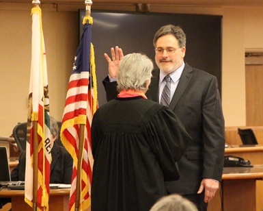 Dennis Rodoni raises his right hand and takes the oath of office from Judge Faye D'Opal.