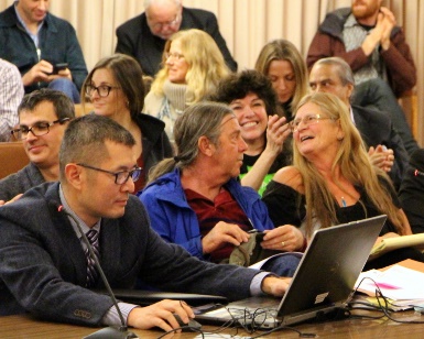 Medical cannabis advocates begin to rejoice as Community Development Agency Assistant Director smiles in the foreground.