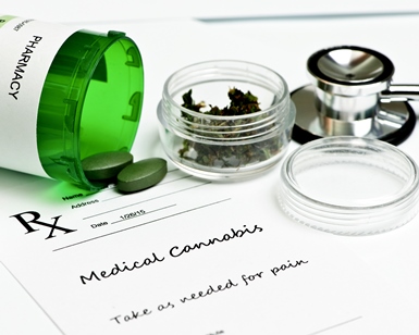 Tablets of medical cannabis on a table with a small container of leaves and a stethoscope