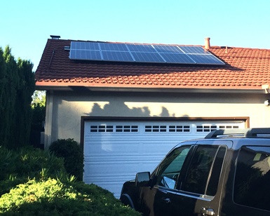 A roof above a home's garage has solar panels on it.
