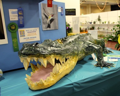 A paper mache alligator made by a child sits on a table during a past County Fair.