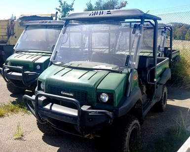 Two utility vehicles similar to golf carts are shown parked in the Public Works lot.