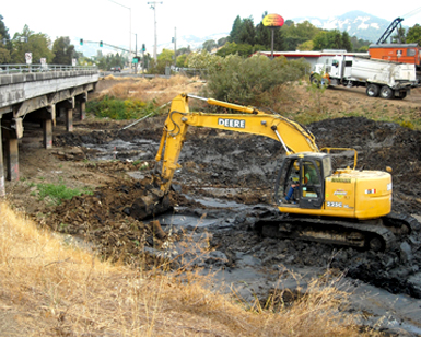 A heavy equipment operator uses an excavator to dredge Novato Creek.