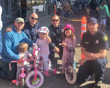 Four firefighters pose with three young girls who received new bikes in Santa Rosa.