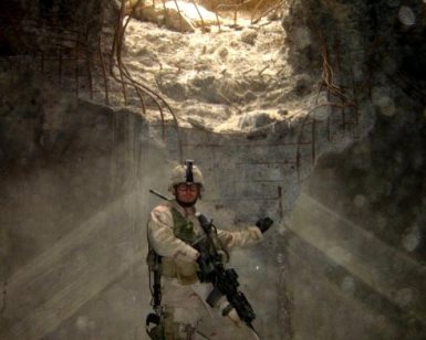 Tom Tarantino is shown in full combat gear in a blown out bunker in the Middle East during one of his deployments.