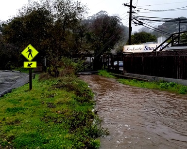 A swollen creek runs past the Parkside Cafe in Stinson Beach