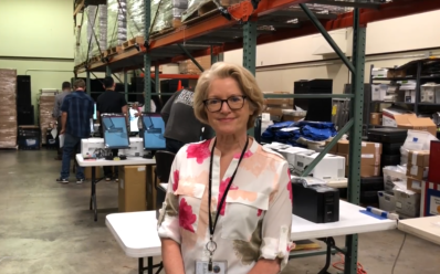 Lynda Roberts at the Election Department warehouse with equipment in the background