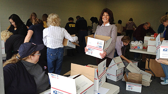 Supervisor Judy Arnold in a room with people packing postal boxes.
