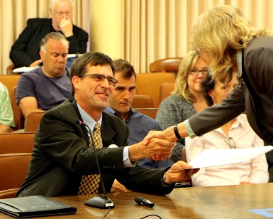 David Lewis shakes the hand of Supervisor Kate Sears during a 2014 Board of Supervisors meeting.