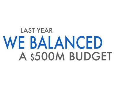 An image from a the video saying "We Balanced a $500 Million Dollar Budget"