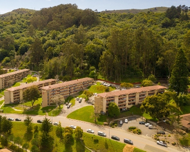 An aerial view of apartments, streets and hills in Marin City