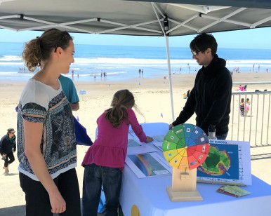 A mother and daughter visit with a sea-level rise expert at the 2017 Shrinking Shores event at Stinson Beach.