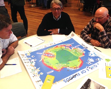 Three men play the Game of Floods board game