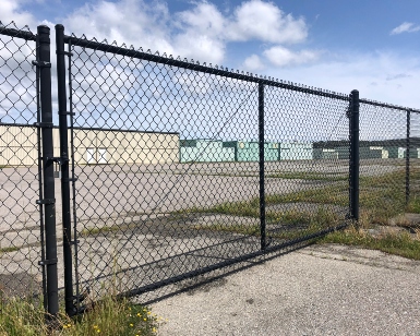 A photo of a large chain-link swinging gate