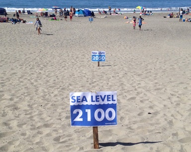 Signs in the sand at Stinson Beach show where expected ocean levels will be in 2050 and 2100.