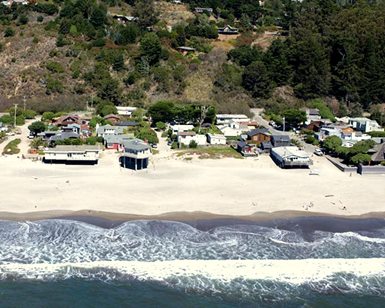 An aerial photo of homes along Stinson Beach very close to the water.