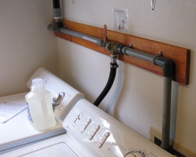 A graywater system of pipes inside a laundry room
