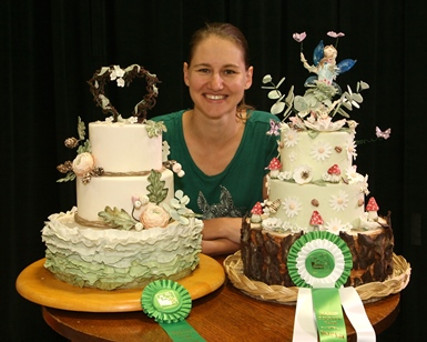 A woman smiles next to her cake entries that won ribbons at the 2016 Marin County Fair.