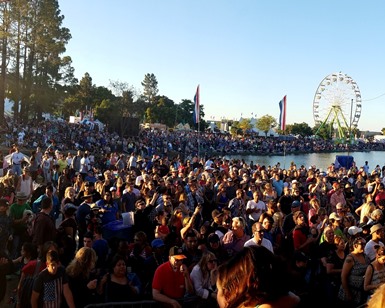 Thousands of spectators are shown at the fairgrounds during one of the music concerts.