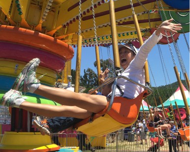A woman appears to be having fun as she rides on a circular-twirling swing at a past Marin County Fair.