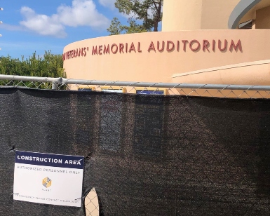 An exterior view of the Veterans' Memorial Auditorium and the fencing and mesh keeping people from going into the construction zone.