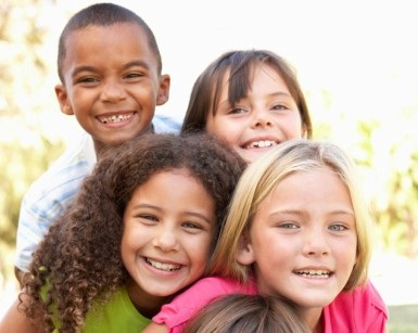 Four children aged about 6-7 years old smile for the camera