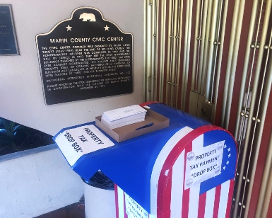 Photo shows a secure drop box for property tax payments right next to the National Historic Landmark plaque at the Civic Center entrance.