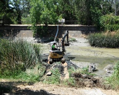 A tractor operator works to dredge a Novato creek