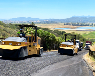 Construction crews use heavy equipment to repave a road