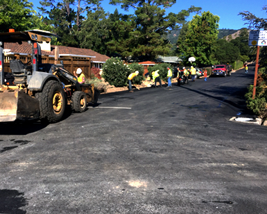A public works crew works to repave a road in the Sleepy Hollow neighborhood.