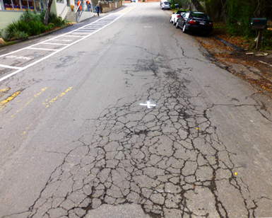 Roadway with cracked pavement.  Melrose Avenue to be repaved from Montford Avenue to Laverne Avenue.