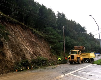 Workers use heavy equipment to clear Sir Francis Drake Boulevard of mud after a mudslide at the junction of Baywood Canyon Road near Fairfax.