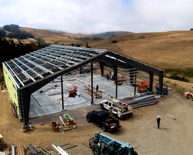 A photo of the new Tomales Fire Station taking shape, with building framing erected but no walls or roof yet.