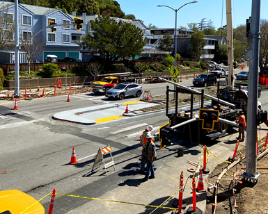 Construction workers install a special electronic crosswalk on Sir Francis Drake Boulevard.