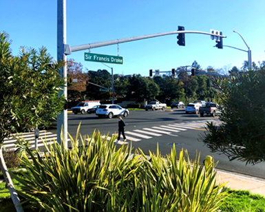 A view from the corner of an intersection along Drake Boulevard shows enhancements with traffic lights, crosswalk, and landscaping.