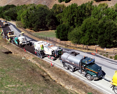 Trucks and heavy equipment are shown during a roads project.