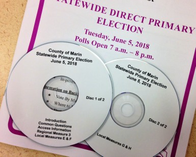 Two audio CDs sit on top of an election booklet