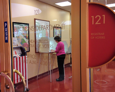 A woman casts a ballot at the voting station inside the Marin County Elections Department