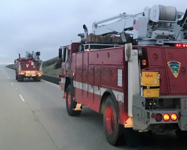 Two fire engines are shown rolling down the highway