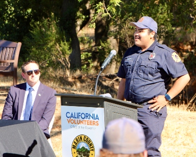 FIRE Foundry participant Juan Armando Jimenez speaks at a lectern during a press conference as State Chief Service Officer Josh Fryday looks on.