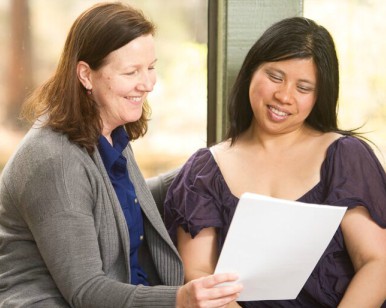 An employee (left) with CareerPoint MARIN assists a client with paperwork.