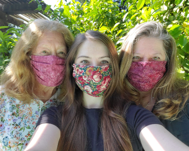 A young girl, her mother and her grandmother wear face coverings to protect from COVID-19.