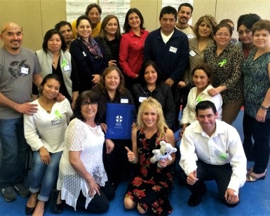 About 20 people pose after a Spanish-language training session for mental health first aid.