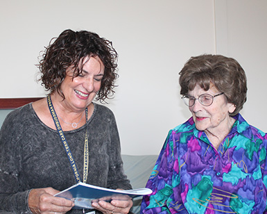 A female staff member from the Ombudsman program (left) speaks to an older woman.