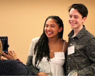 Two teens smile as they hold their awards at the 2017 Humanitarian Awards.