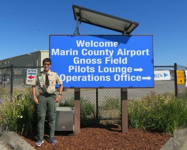 Intern and Boy Scout Tyler Colenbrander stands next to his 24-hour solar-powered welcome sign he designed and installed with volunteer friends at Gnoss Field, Marin County's airport in Novato.
