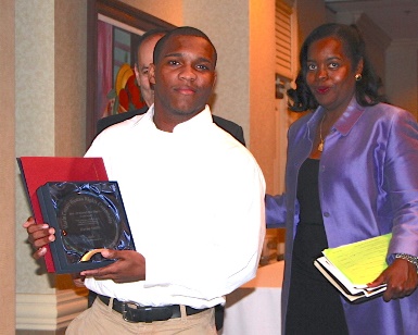 A young man accepts a plaque during the 2015 MLK Awards.