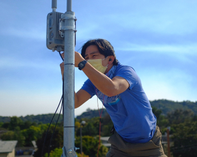 Vinh Pham, the City of San Rafael's data and infrastructure manager, works on WiFi installation on the roof of a building.