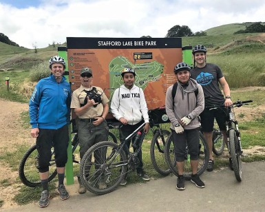 Four mountain bikers, including two kids of about 12 years old, pose with a park ranger at the Stafford Lake Bike Park.